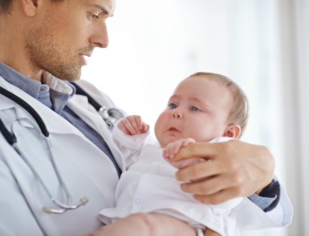 Foto médico bebé enfermo y triste en la clínica para la evaluación de la salud pediatría apoyo y ayuda pediatra sosteniendo a un niño recién nacido infeliz para el examen médico del servicio hospitalario y el bienestar de los niños que lloran