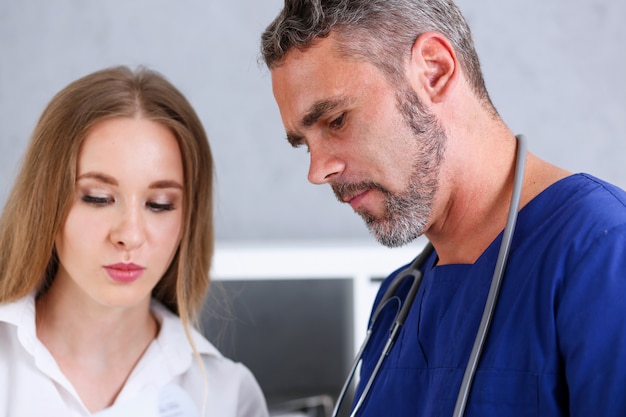 Médico bonitão sorridente se comunicar com o paciente