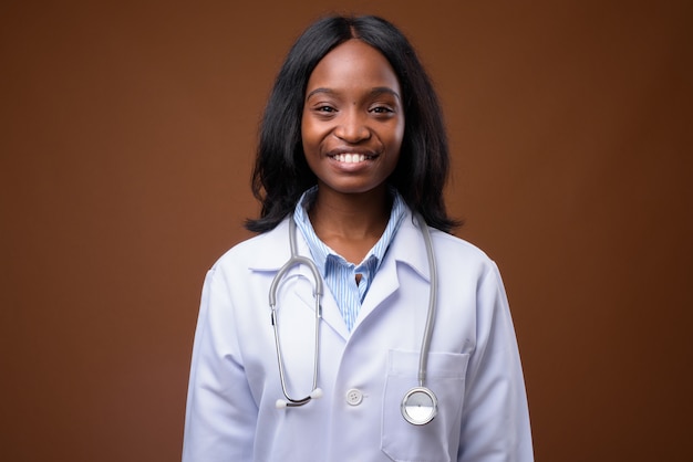 Médico bonito jovem mulher Zulu Africano contra backgroundu marrom