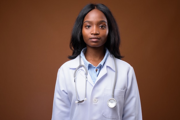 Médico bonito jovem mulher Zulu Africano contra backgroundu marrom