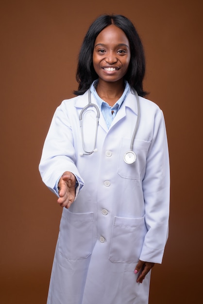 Médico bonito jovem mulher Zulu Africano contra backgroundu marrom