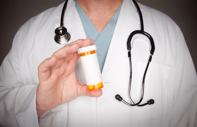 Médico con una botella de medicina en blanco