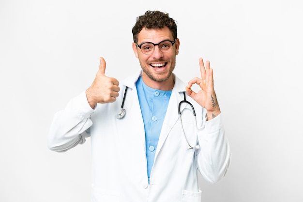 Médico brasileiro sobre fundo branco isolado, mostrando o sinal de ok e o polegar para cima gesto