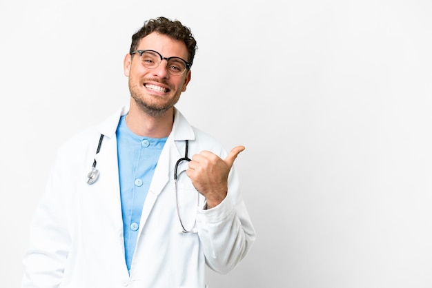 Foto médico brasileño hombre sobre fondo blanco aislado apuntando hacia un lado para presentar un producto