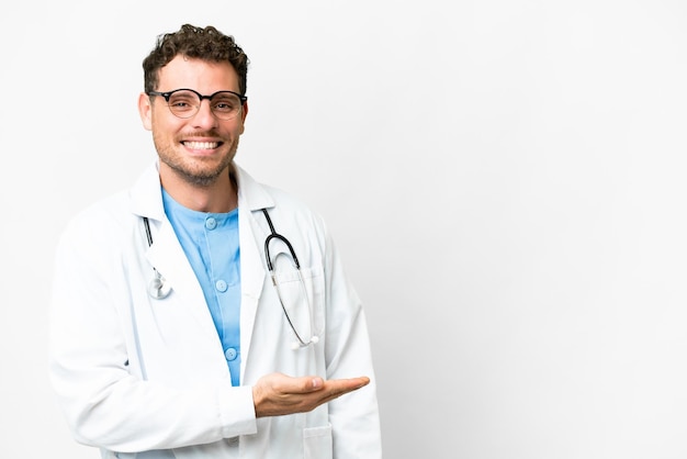 Médico brasileño sobre fondo blanco aislado que presenta una idea mientras mira sonriendo hacia