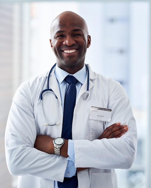 Médico con los brazos cruzados y retrato de hombre negro en el hospital con confianza para la confianza apoyo médico o bienestar Ayuda a la medicina y al médico con estetoscopio para consultar atención médica o servicios