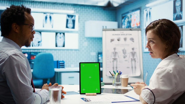 Foto el médico de cabecera señala el modelo de pantalla verde en el dispositivo