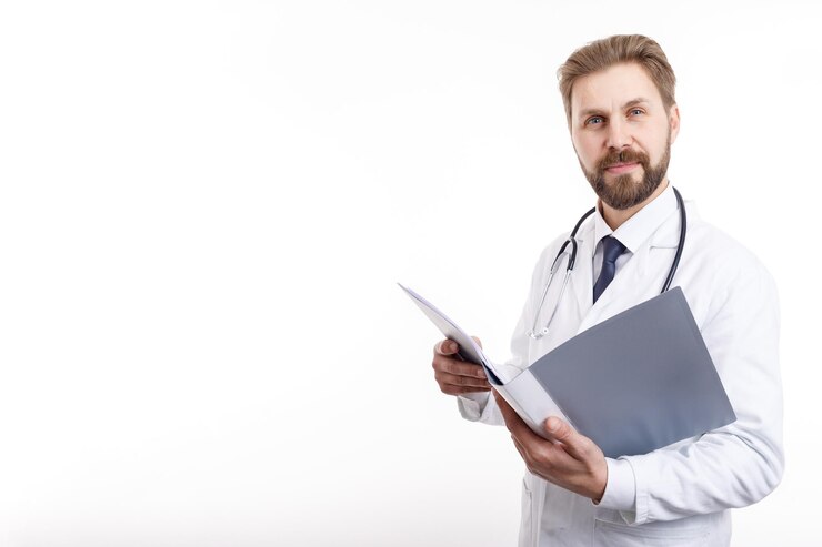 Médico de cabello castaño barbudo sonriente posando con una carpeta abierta