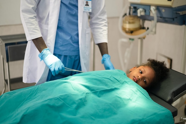 Médico de cáncer quirúrgico con equipo médico quirúrgico profesional para niños operando cirugía a un paciente en el quirófano del hospital