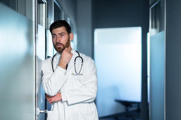 El médico cansado con exceso de trabajo tiene un fuerte dolor de cabeza y se siente mal. Un hombre en el pasillo de la clínica está decepcionado con el resultado.