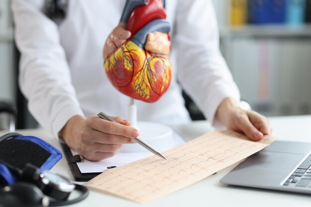 Médico cardiologista examina eletrocardiograma do coração do paciente em cardiologia