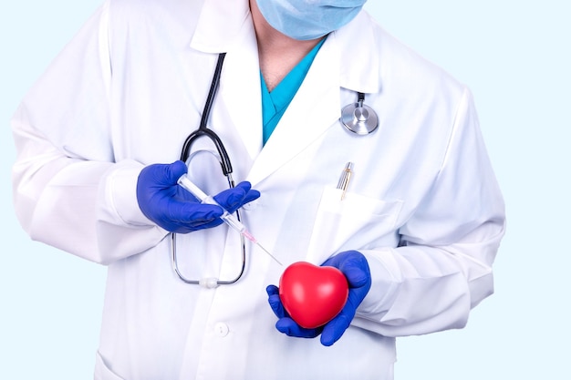 Médico cardiologista tem um coração e uma seringa nas mãos. conceito médico.