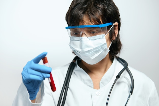 Médico científico sosteniendo un tubo de ensayo con sangre para analizar el coronavirus