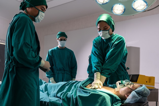 Foto médico cirujano y enfermera hacen rcp al paciente