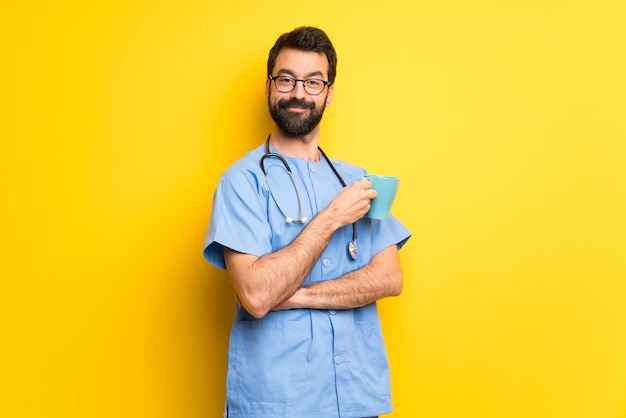 Médico cirujano hombre sosteniendo una taza de café caliente