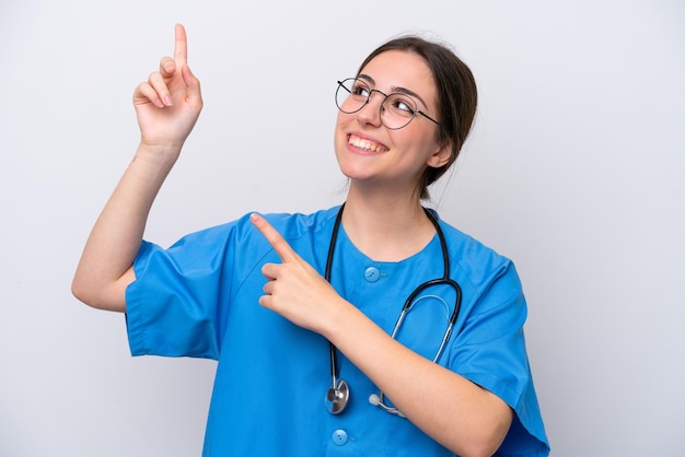 Médico cirujano mujer sosteniendo herramientas aisladas sobre fondo blanco apuntando con el dedo índice una gran idea