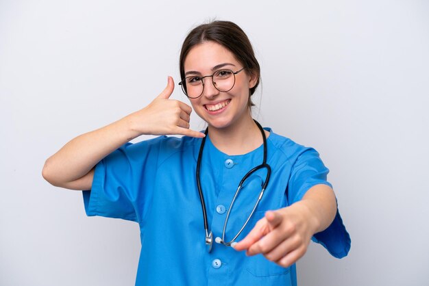 Médico cirujano mujer sosteniendo herramientas aisladas sobre fondo blanco haciendo gesto de teléfono y apuntando al frente