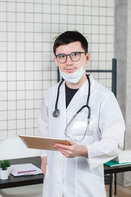 Médico cirurgião com computador tablet no escritório do hospital.