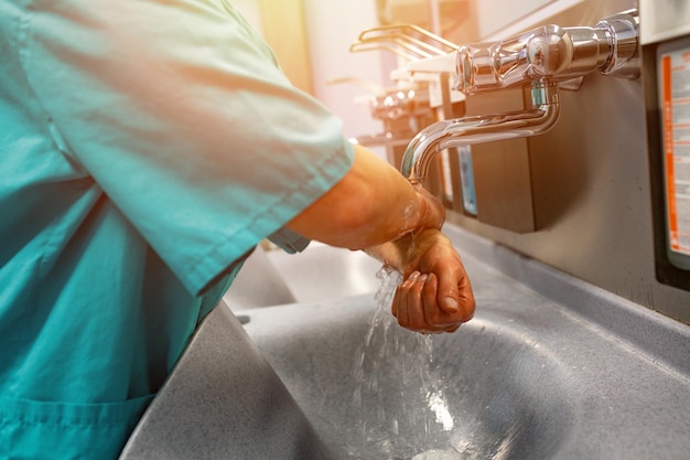 Médico cirurgião se preparando para cirurgia e lava as mãos