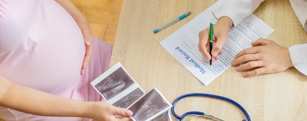 Un médico en una clínica examina a una mujer embarazada.