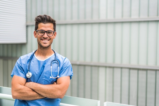 Médico com braços cruzados posando