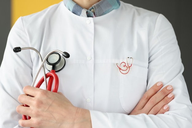 Médico com broche uniforme segurando o close do estetoscópio