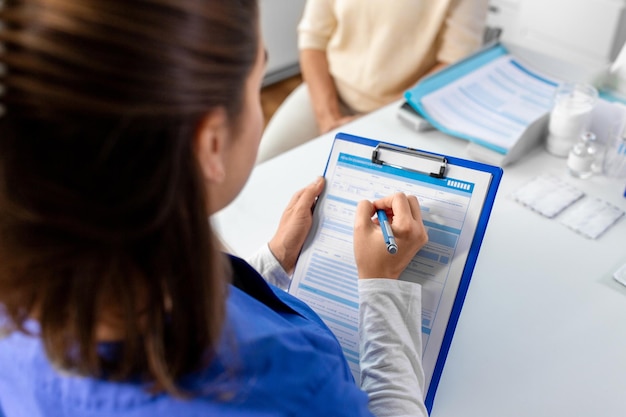 médico com clipboard e mulher sênior no hospital