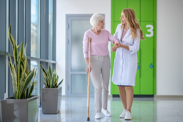 Médico com jaleco e um paciente caminhando juntos e conversando