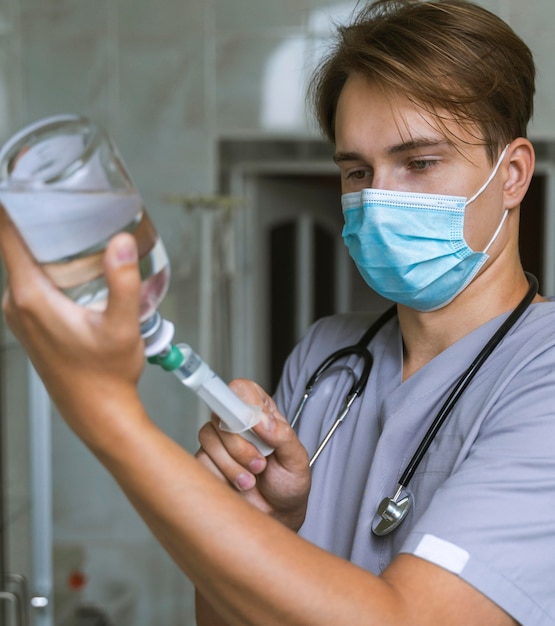 Médico com máscara médica enchendo seringa com remédio