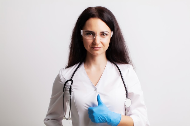 Médico com óculos de proteção e estetoscópio no seu espaço de trabalho