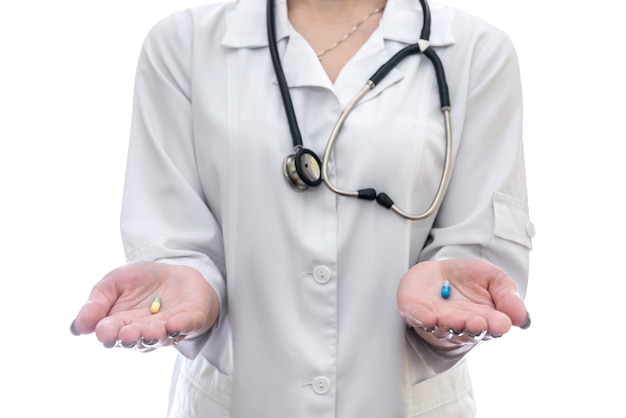 Médico com pílulas coloridas na palma da mão isoladas em branco