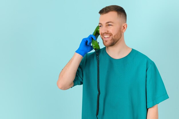 Médico com telefone em um conceito de chamada de médico de fundo azul