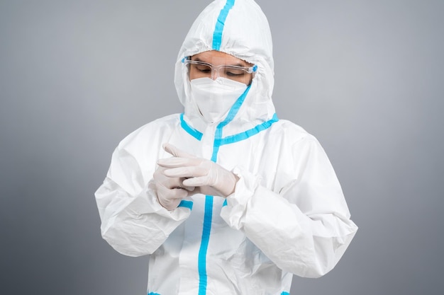 Médico com traje de proteção de epi e luvas de borracha para as mãos contra a pandemia de coronavírus (covid-19)