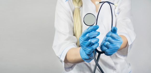 Médico com um estetoscópio na mão em uma mesa de luz. Conceito de medicina. Epidemia