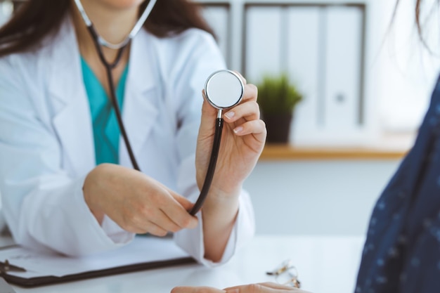 Médico com um estetoscópio na mão. O médico está pronto para examinar sua paciente.