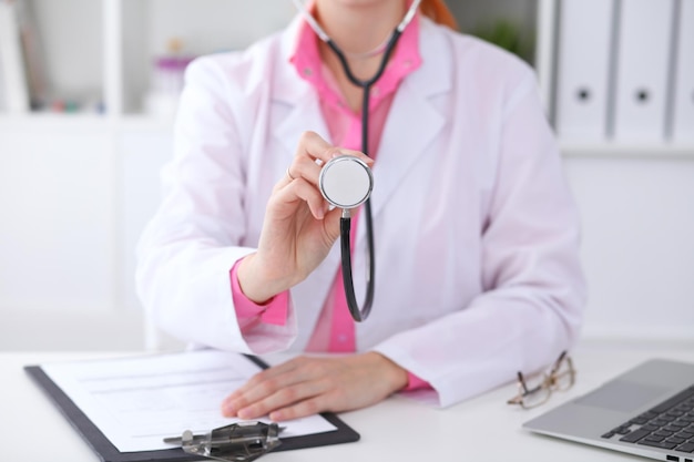 Médico com um estetoscópio nas mãos. cena de cor rosa