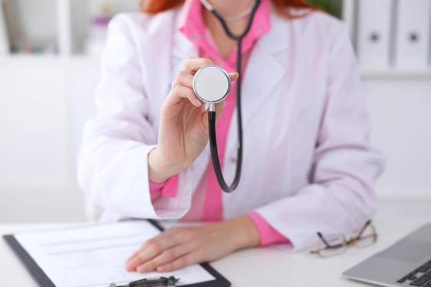 Médico com um estetoscópio nas mãos. cena de cor rosa