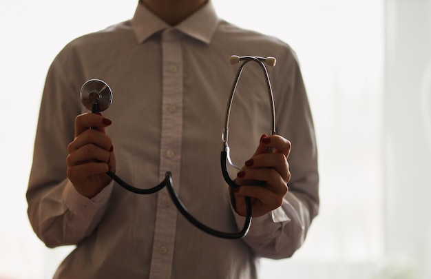 médico com um estetoscópio no fundo do hospital Um médico de jaleco branco com um estetoscópio