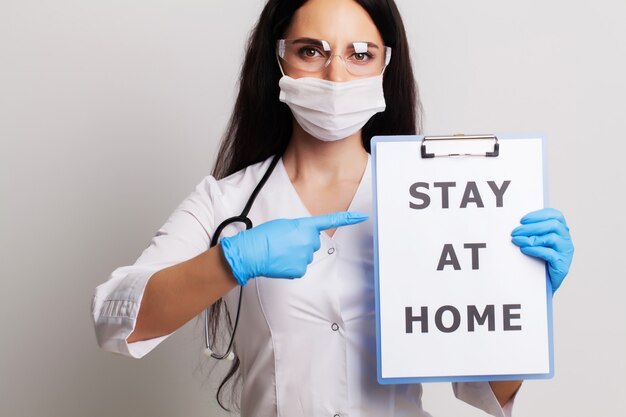 Médico com um papel com ficar em casa segurando na mão