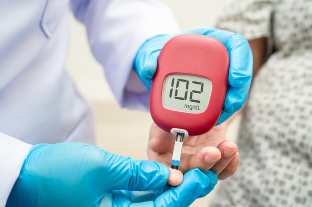 El médico comprueba la diabetes a partir del nivel de azúcar en la sangre del dedo con una lanceta del dedo