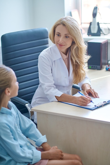 Médico concentrado sentado en el escritorio durante la consulta pediátrica