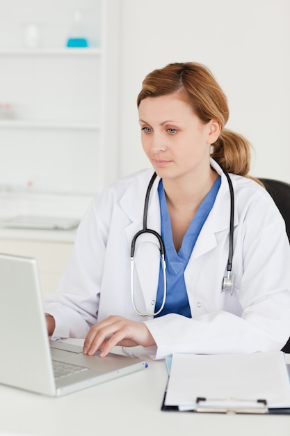 Médico concentrado trabalhando em seu laptop