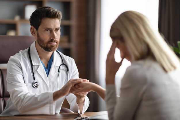 Médico consolando paciente do sexo feminino após compartilhar más notícias na clínica