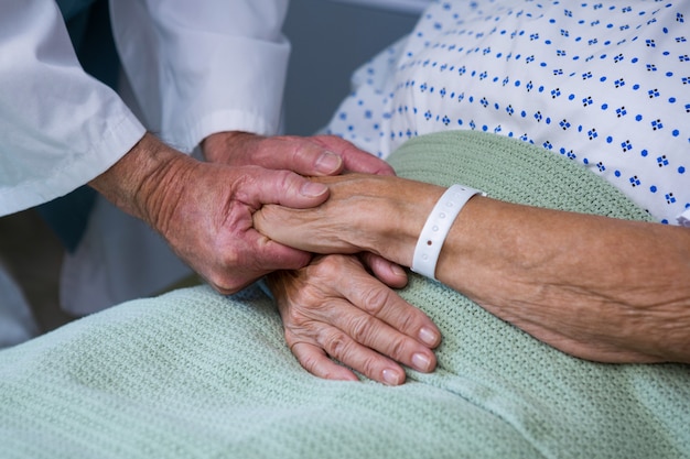 Médico consolando paciente idoso no hospital