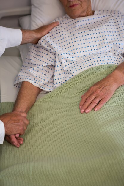 Foto médico consolando paciente sênior