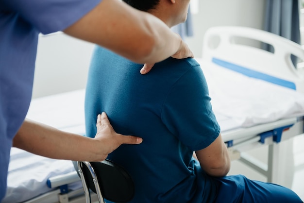 Médico consultando o paciente Problemas nas costas Físico na cama no conceito de clínica xA