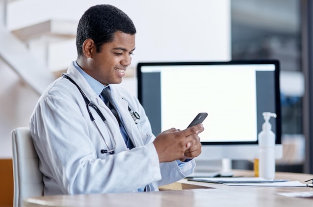 Médico consultando um paciente on-line em chamada de vídeo em um telefone fazendo telemedicina e ouvindo durante uma consulta médica Trabalhador profissional sorridente feliz lendo e-mail e verificando o planejador