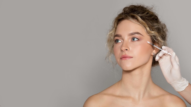 Foto médico cosmetologista fazendo injeção de botox para área dos olhos para jovem mulher recebendo anti-rugas