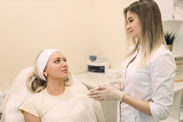 médico cosmetólogo se comunica con una paciente después de los procedimientos