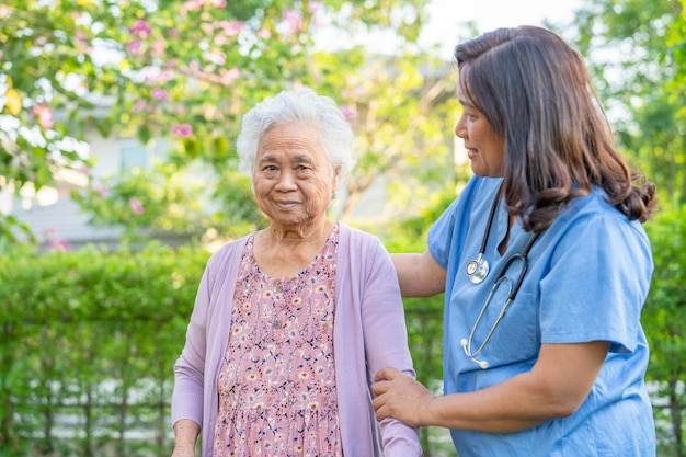 Foto médico cuidador ajuda e cuidados asiática mulher idosa paciente caminhar com caminhante no parque no hospital